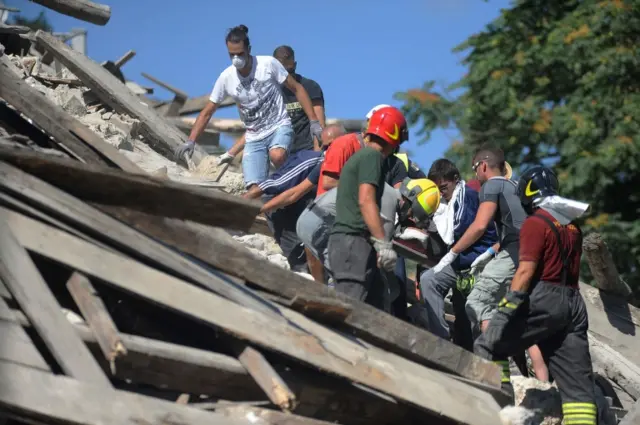 Rescuers amid the debris in Pescara del Tronto