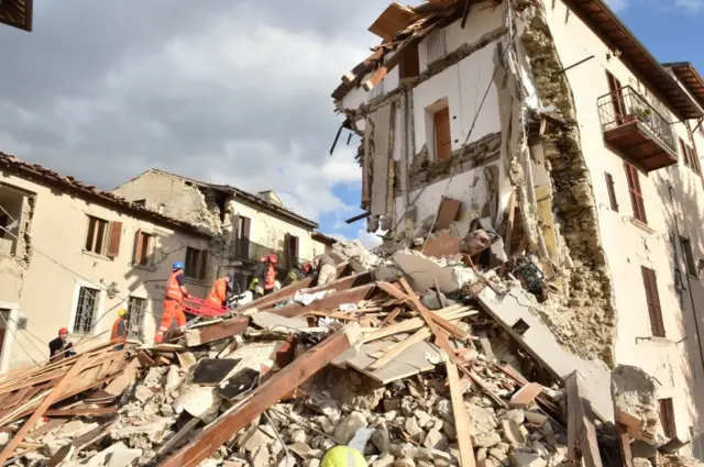 Rescuers clear debris while searching for victims in Arquata del Tronto