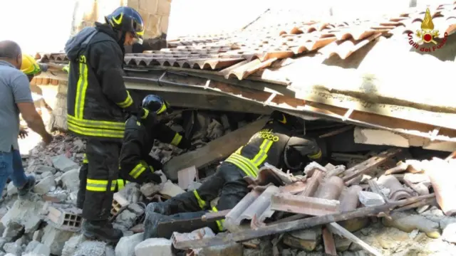 Firefighters searching for quake victims amid the rubble of collapsed buildings in Amatrice