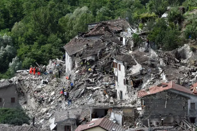 Search and rescue teams survey the rubble of collapsed and damaged houses in Pescara del Tronto, near Arquata del Tronto municipality