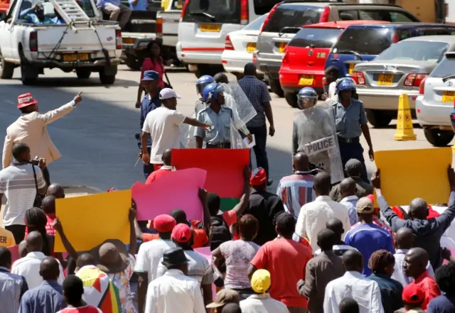 Locals hold placards during a protest by opposition youths who were demonstrating against alleged brutality by security agents in the capital Harare, Zimbabwe August 24, 2016