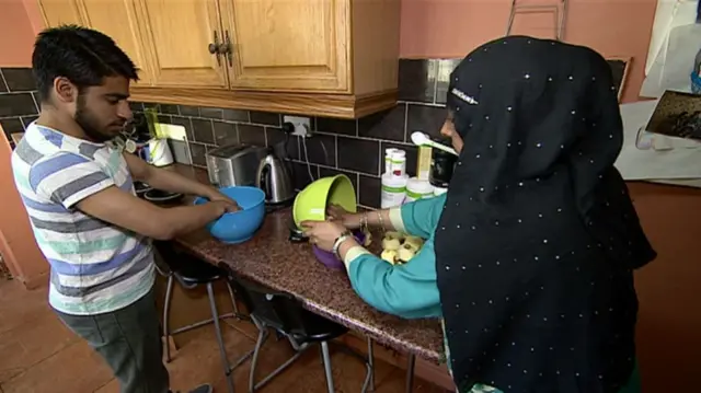 Two people in a kitchen cooking