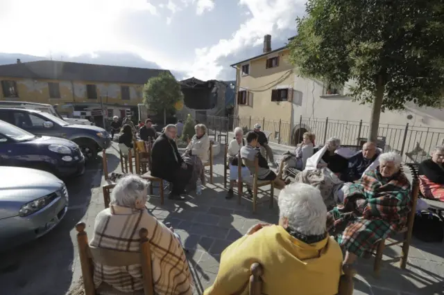 Eldery residents sit outdoors in Cumuli