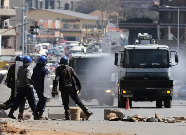 Anti-riot police clear roads during a protest by opposition youths who were demonstrating against alleged brutality by security agents in the capital Harare, Zimbabwe August 24, 2016.