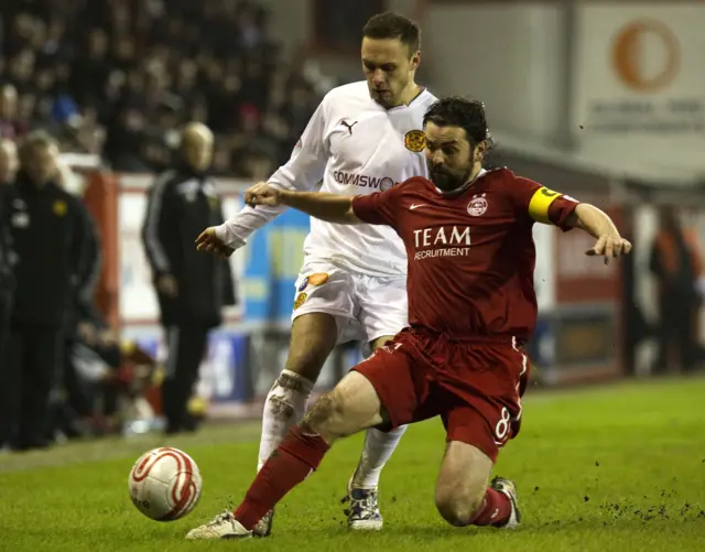 Paul Hartley slides in to challenge Motherwell's Tom Hateley