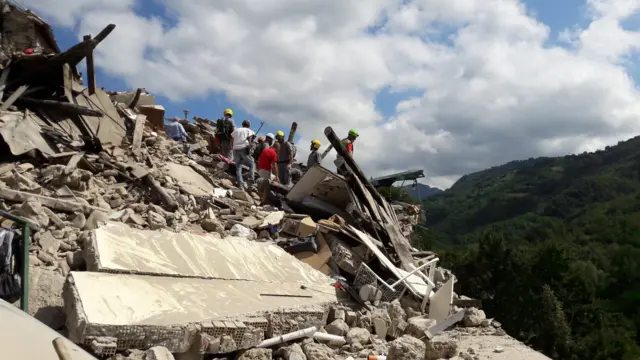 A team of rescuers on a pile of rubble