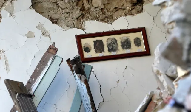 The interior of a house in Amatrice with pictures still hanging on a wall (25 August 2016)