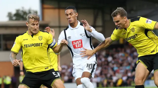 Tom Ince of Derby County, is challenged by Burton's defenders