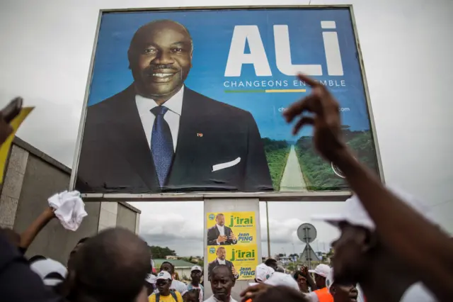 Ali Bongo poster above Jean Ping poster