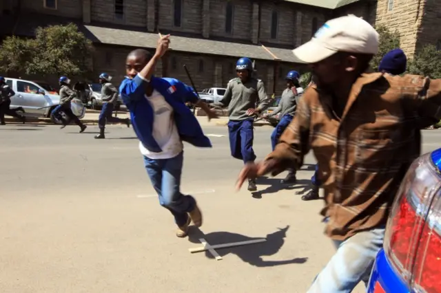 Zimbabwe police officers clash with protestors and journalists, in Harare, Wednesday, Aug. 3, 2016.