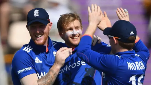 Joe Root (centre) celebrates a wicket