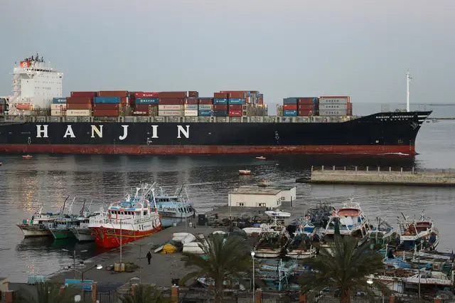 A container ship, belonging to Korea's Hanjin shipping, sails down the Suez Canal city of Port Said