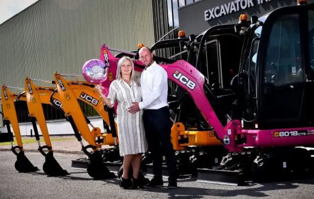 Row of JCB diggers with expectant parents