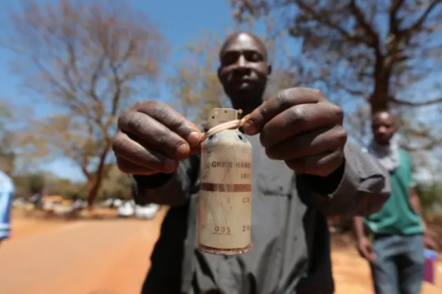 Man holding tear gas cannister