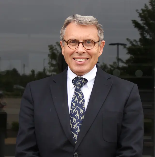 Lorne Green in dark suit, white shirt and animal-print tie