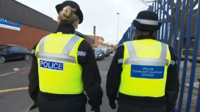 Police officers walking down a street