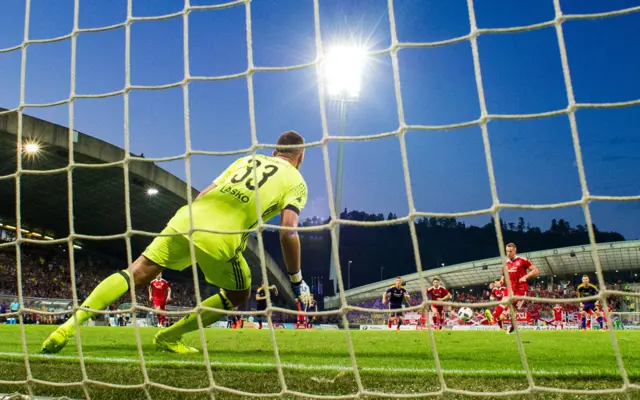 Adam Rooney sends a rather weak penalty kick towards the Maribor goal and soon watches in horror as it is saved.