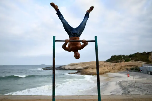 Man exercises on a beach in Rio