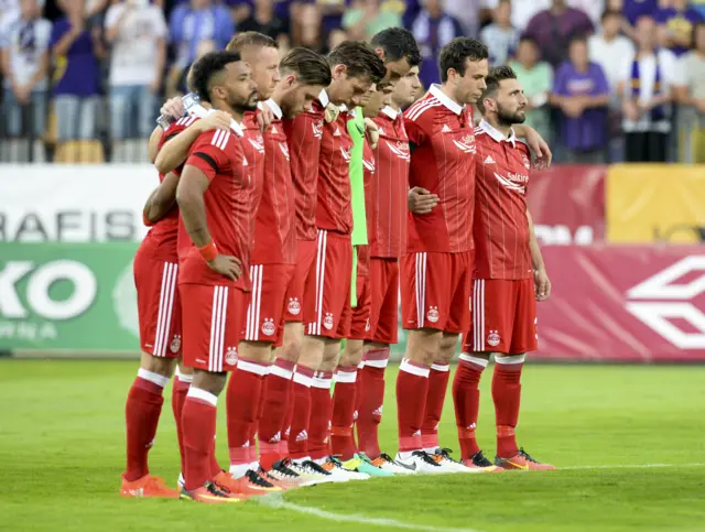 The Aberdeen players pause for a minute's silence to mark the awful loss of two of Maribor's fringe players.