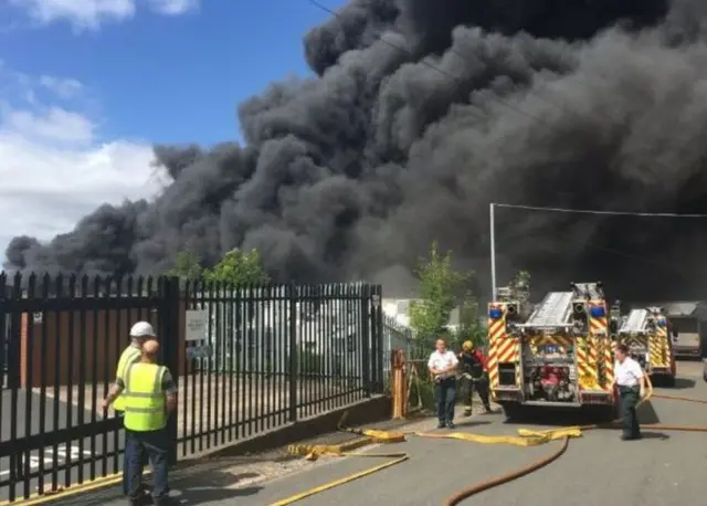 Fire engine and thick smoke blowing out of large fire