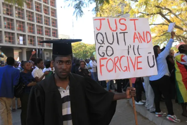 Samuel Meso holds a banner with a message directed at Zimbabwean President Robert Mugabe while taking part in a demonstration in Harare in this Wednesday, August, 3 2016 photo.