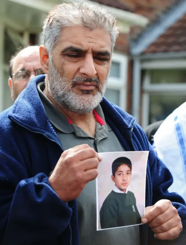 Tariq Jahan holding a picture of his son