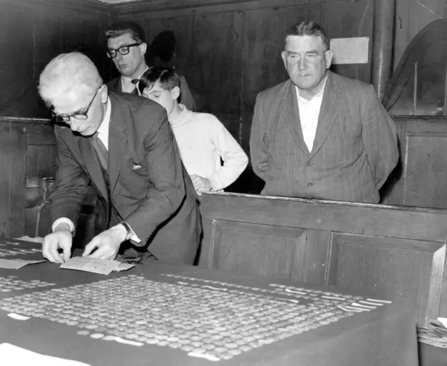 Cyril Agger, who discovered 1,100 ancient coins at Hartford near Huntingdon, looks on as County archivist Philip Dickinson lays out the coins