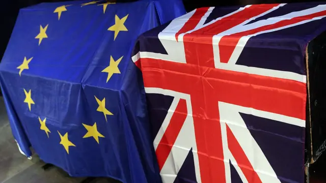 European Union (L) and British Union Jack flags hang at a meeting for British citizens living in Germany to discuss the implications of Great Britain leaving the European Union