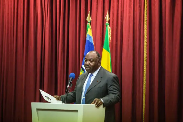 President Bongo at the lectern with Gabon flag behind him