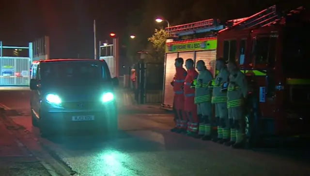 A guard of honour forms as one of the missing workmen is removed from Didcot power station