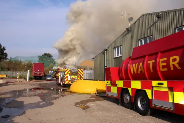 Fire engines at wood pile fire