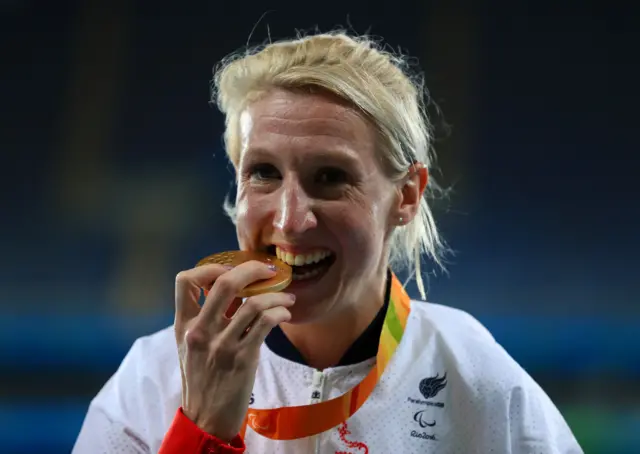 Georgina Hermitage bites her gold medal after winning the T37 100m gold at the Rio Paralympics