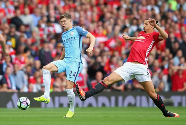 Zlatan Ibrahimovic of Manchester United is tackled by John Stones of Manchester City