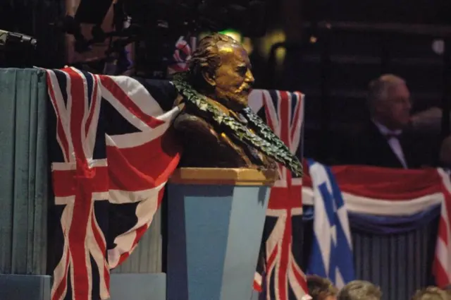 Bust of Sir Henry Wood covered with flags and laurel wreath