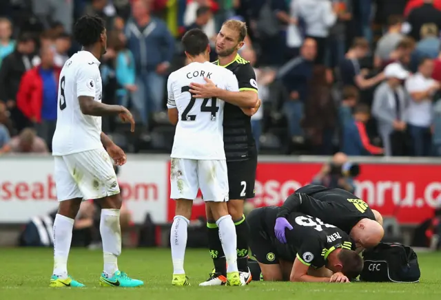 Players embrace as Terry receives treatment at the end of the match