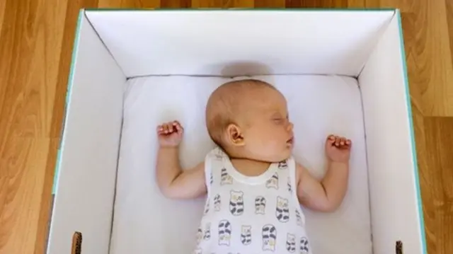 Baby sleeping in a box