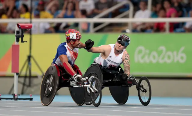 David Weir high-fives a fellow competitor after competing