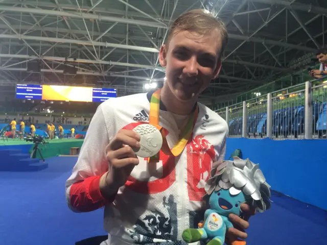 Piers Gilliver holding his silver medal after collecting it at the medal ceremony