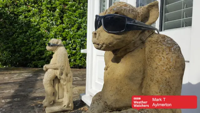 Two stone statues wearing sunglasses