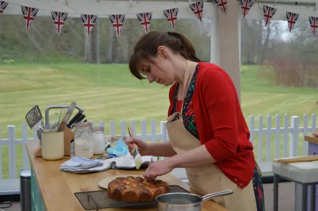 Kate in last week's episode, wearing red cardigan, making bread