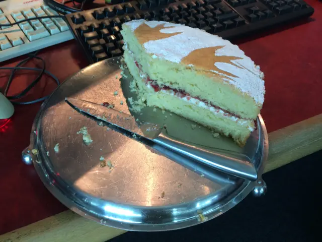 The cake on a plate, most of it has been cut and taken away