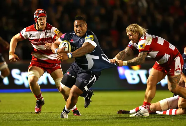 Halani Aulika of Sale Sharks is tackled by Richard Hibbard of Gloucester