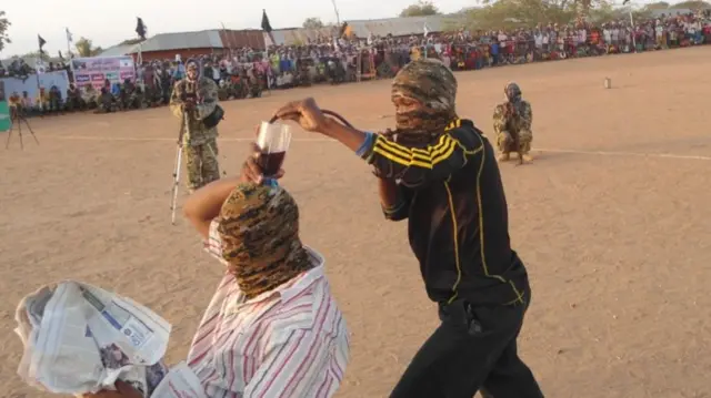 Al-Shabab fighters playing a "glass on head" game, Somalia