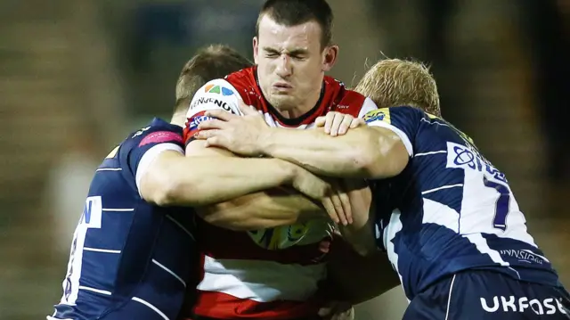 Matt Scott of Gloucester is tackled by Sam James and David Seymour of Sale Shark