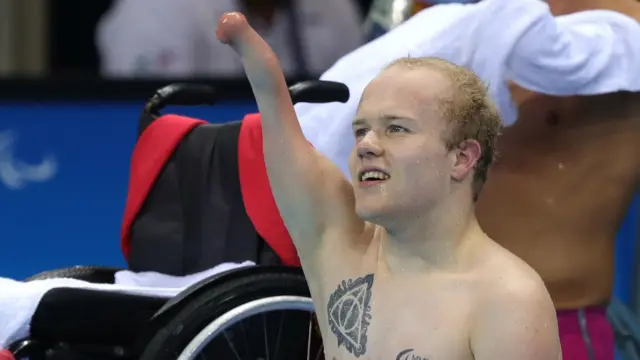 Andrew Mullen sits on the poolside in Rio and celebrates