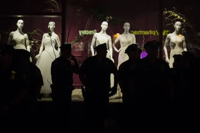 Police officers in front of a shop window