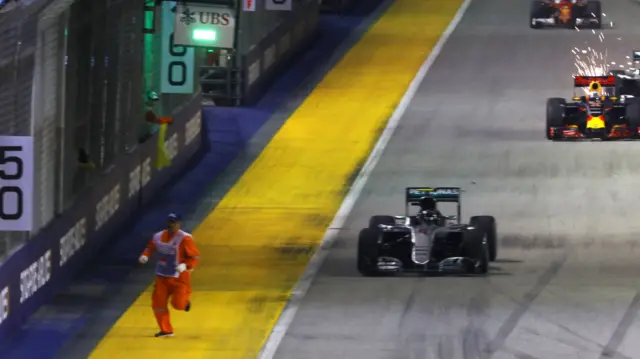 A marshal runs from the track as the race resumes