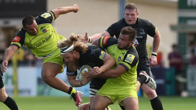 Evan Olmstead of Newcastle is tackled by George McGuigan