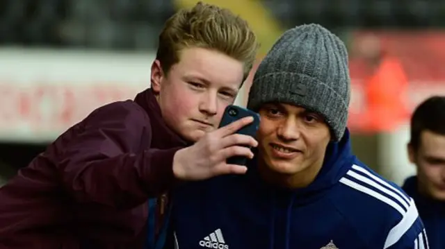 Wes Brown has a picture taken with a fan