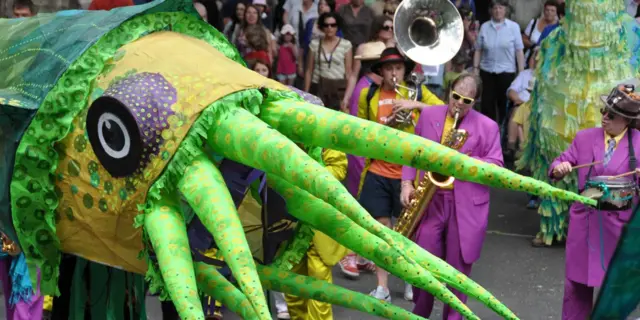 Large squid puppet and musicians during a parade